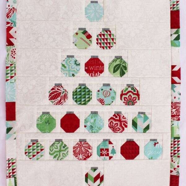 "Christmas Baubles Quilt” is a Free Christmas Quilt Charm Pack Pattern designed by Jen Daly from Moda Fabrics!